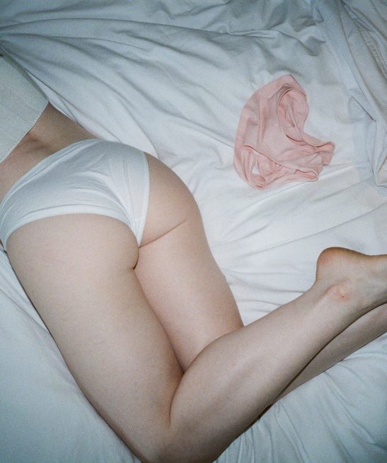 Woman's bottom lying on white sheet