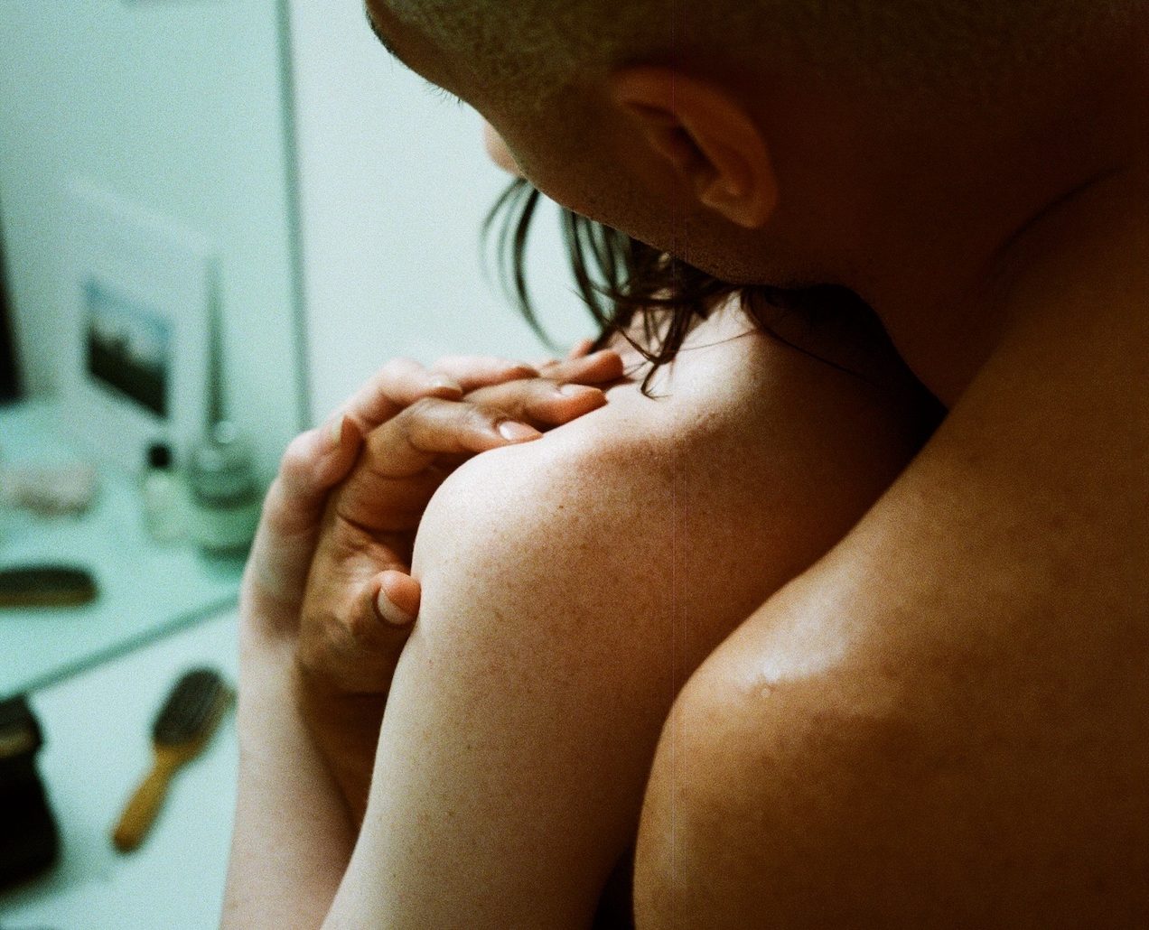 Close up of the back a couple inside a bathroom