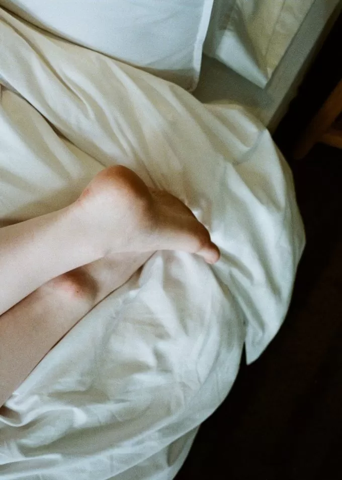 Feet of a woman lying on a bed