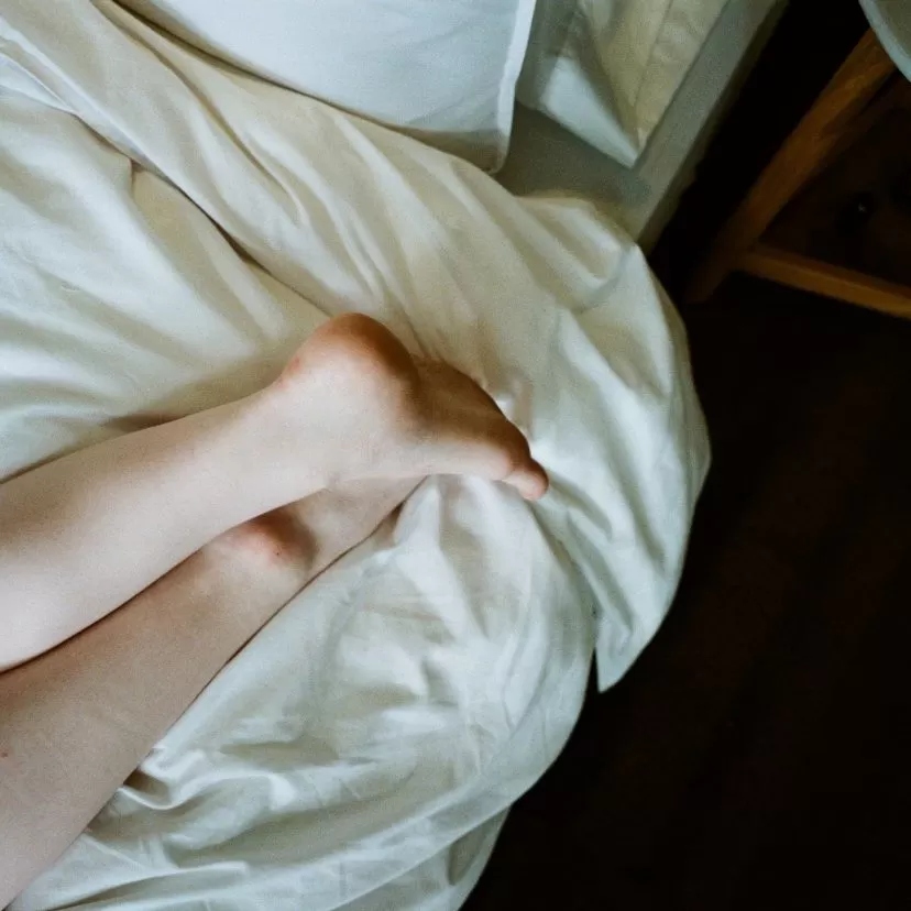 Feet of a woman lying on a bed