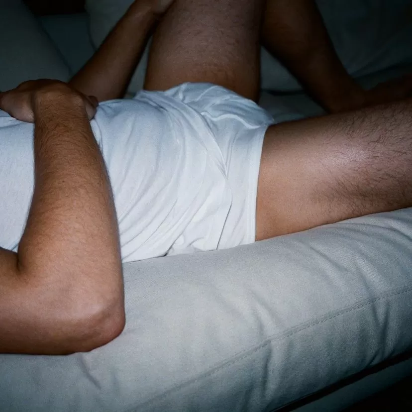 Male torso lying on a sofa