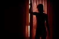Silhouette behind closed red curtains