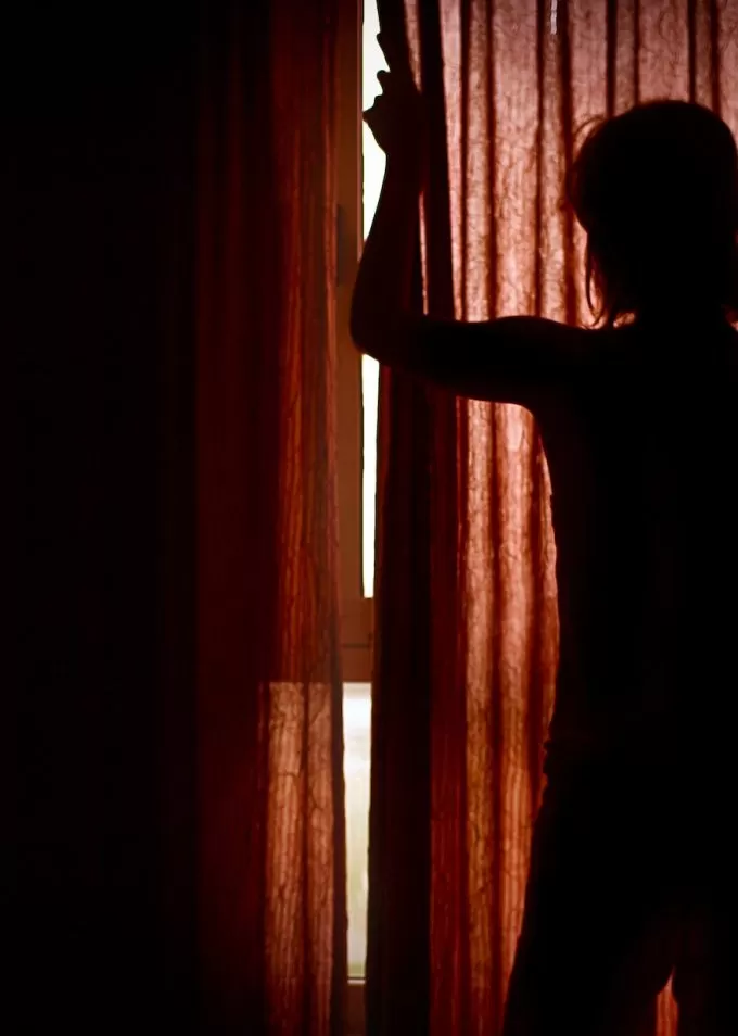 Silhouette behind closed red curtains