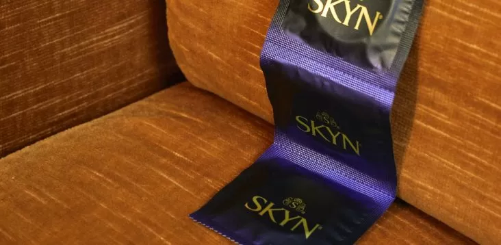 Strip of SKYN condoms over a sofa