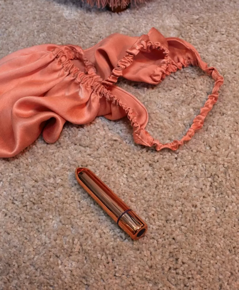 SKYN Thrill sex toy next to a pink nightie