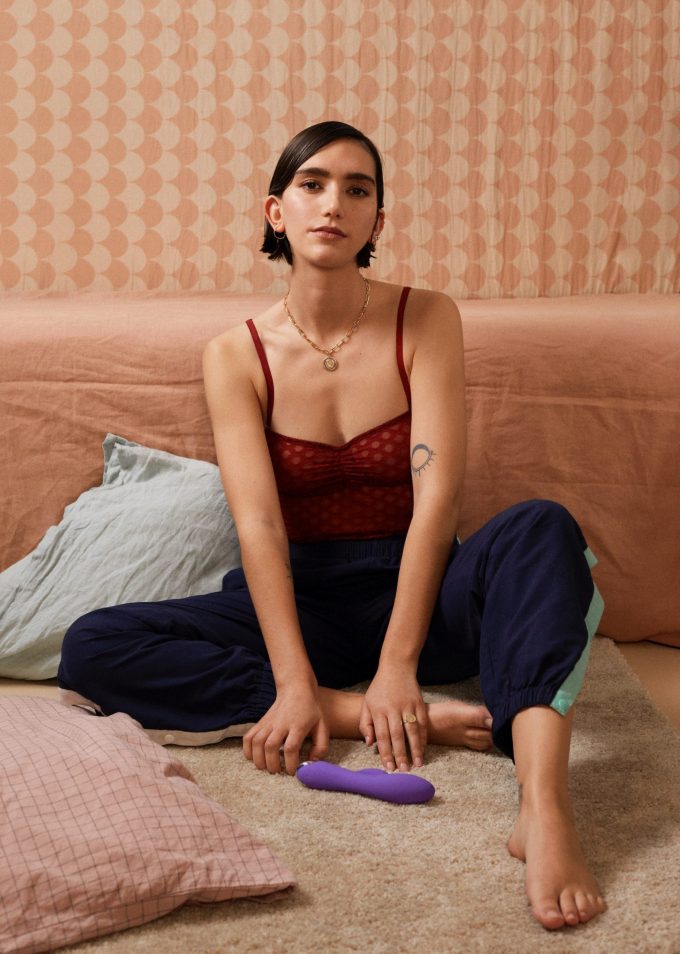 Girl sitting with SKYN Vibes sex toy on the ground