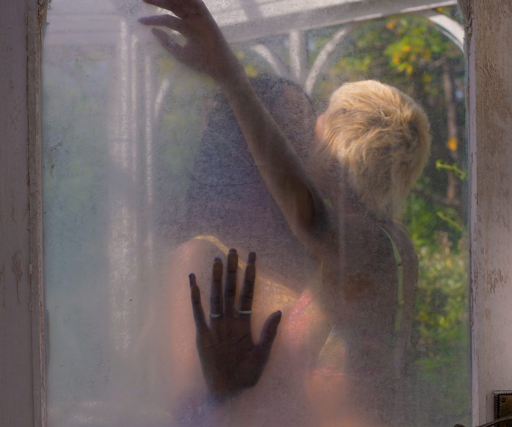 Two girls kissing seen from a frozen glass door Two girls kissing seen from a frozen glass door