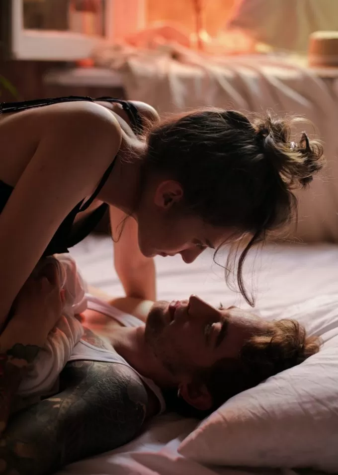 A girl on top of a her man in bed and about to kiss A girl on top of a her man in bed and about to kiss